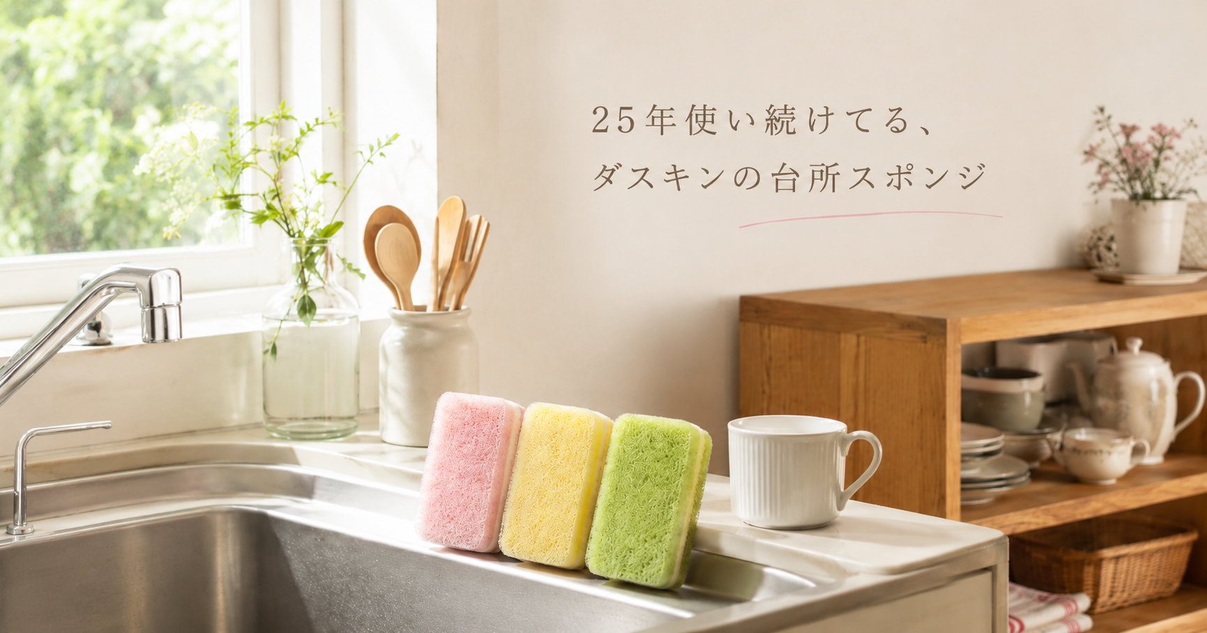 明るいキッチンのシンクに並ぶ、ピンク・イエロー・グリーンの3色スポンジ